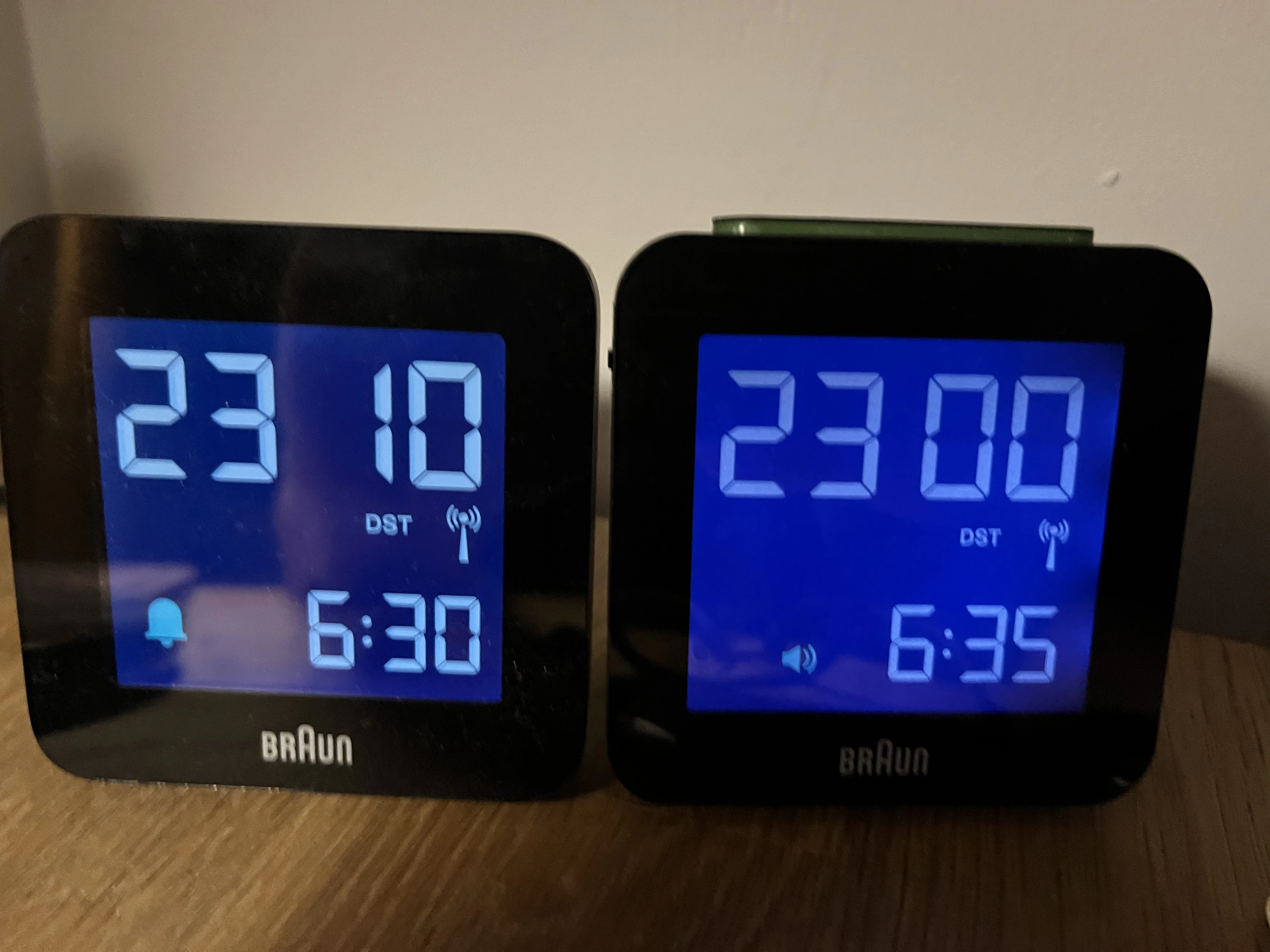 Two alarm clocks of the same kind displaying different times